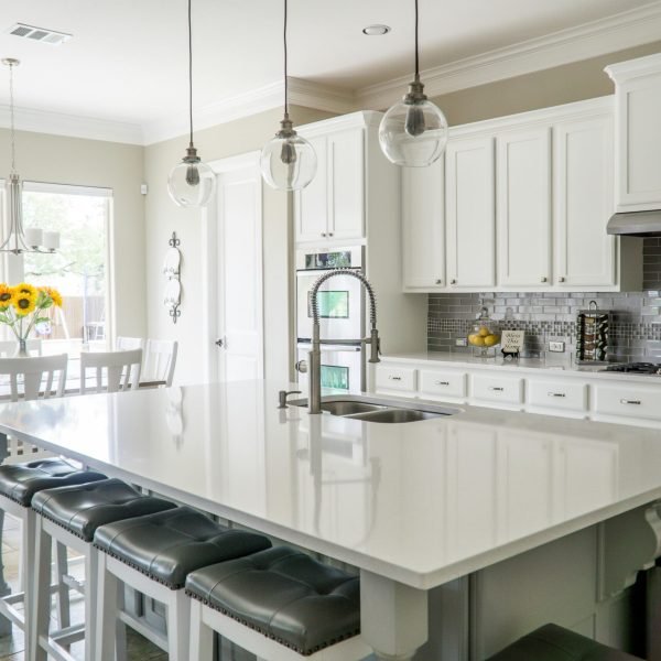 Spacious modern kitchen with white cabinets and island in natural light.